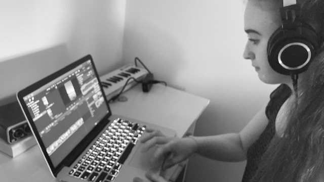 Ellie Kenny editing audio on a laptop